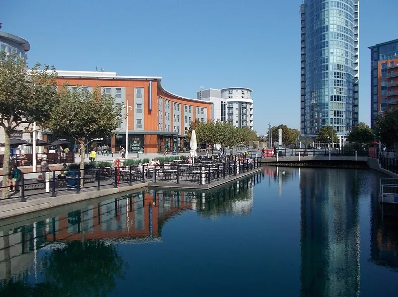Uteservering og moderne bygg ved vannkanten på Gunwharf Quays i Portsmouth