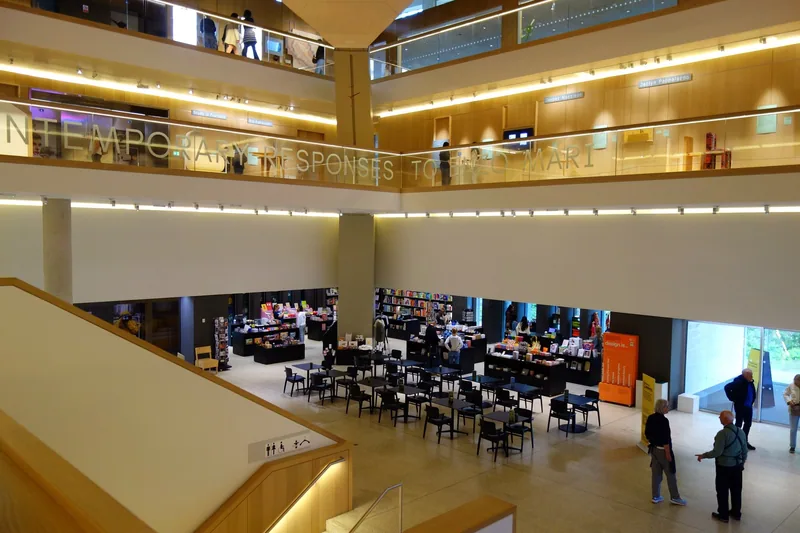 Atriet i Design Museum med kafébord og museumsbutikk i første etasje og gallerier i etasjene over