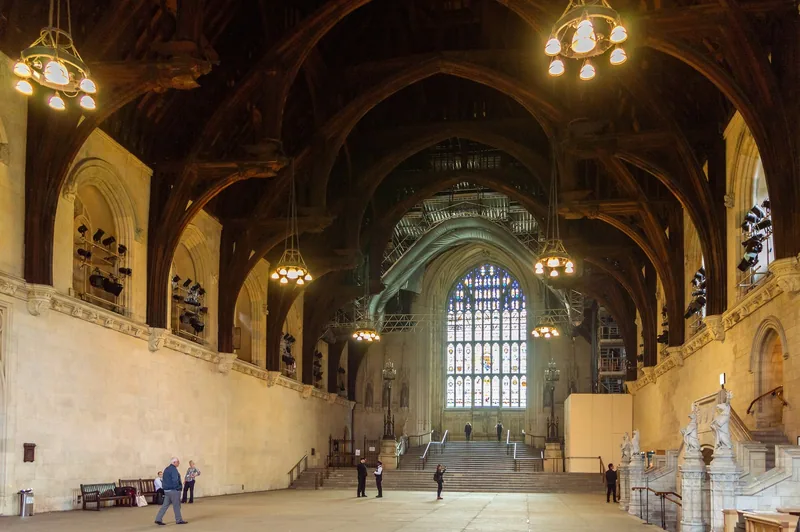 Westminster Hall innvendig, med det høye takverket i tre, lysekroner og trappen opp mot det store glassmaleriet