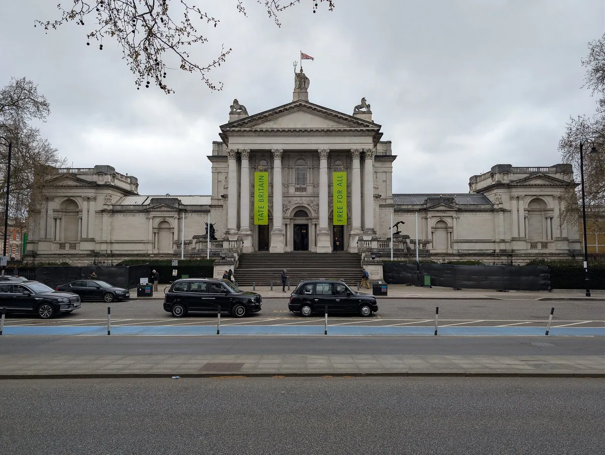 Søylefasaden til Tate Britain ved Millbank med trappen opp til inngangen og svarte drosjer foran