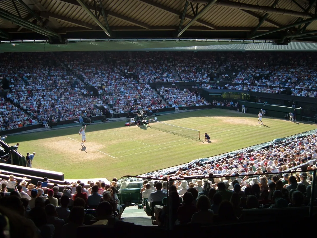 Centre Court i Wimbledon under en kamp, med gressbanen omgitt av fullsatte tribuner