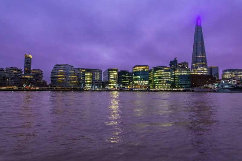 Sørbredden av Themsen i skumringen med opplyste kontorbygg, det runde City Hall-bygget og The Shard