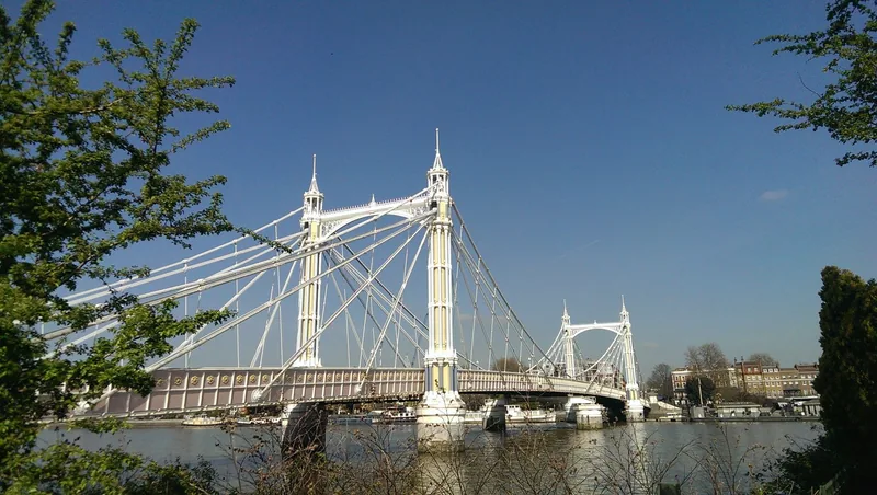 Den hvite hengebrua Albert Bridge over Themsen, sett fra Battersea Park en solrik dag
