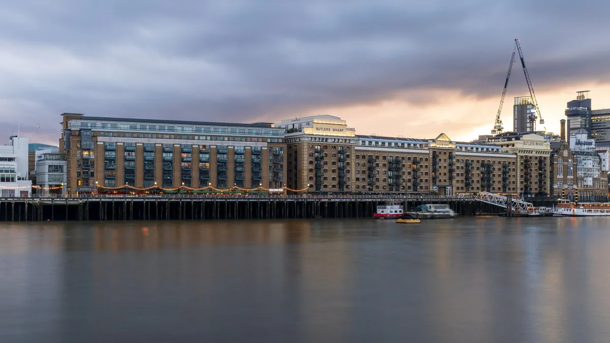 Butler's Wharf og de gamle lagerhusene ved Shad Thames, sett over Themsen i skumringen