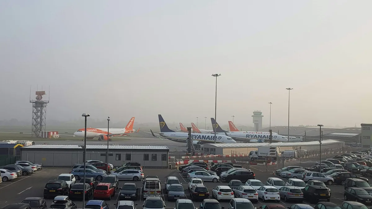 Fly fra easyJet og Ryanair på oppstillingsplassen ved London Southend Airport en disig morgen, med parkeringsplass foran