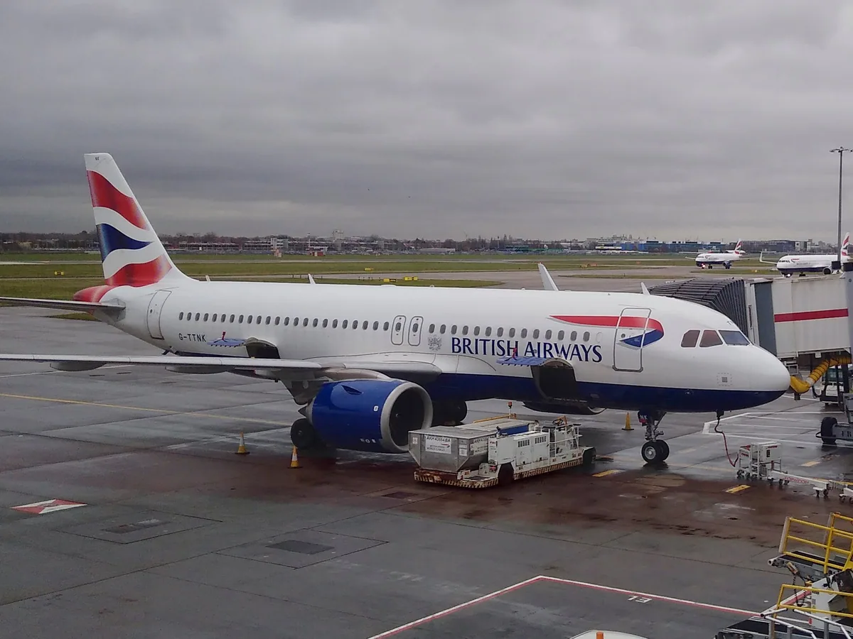 Fly fra British Airways parkert ved en gate på Heathrow Terminal 5 en grå dag, med flere fly i bakgrunnen