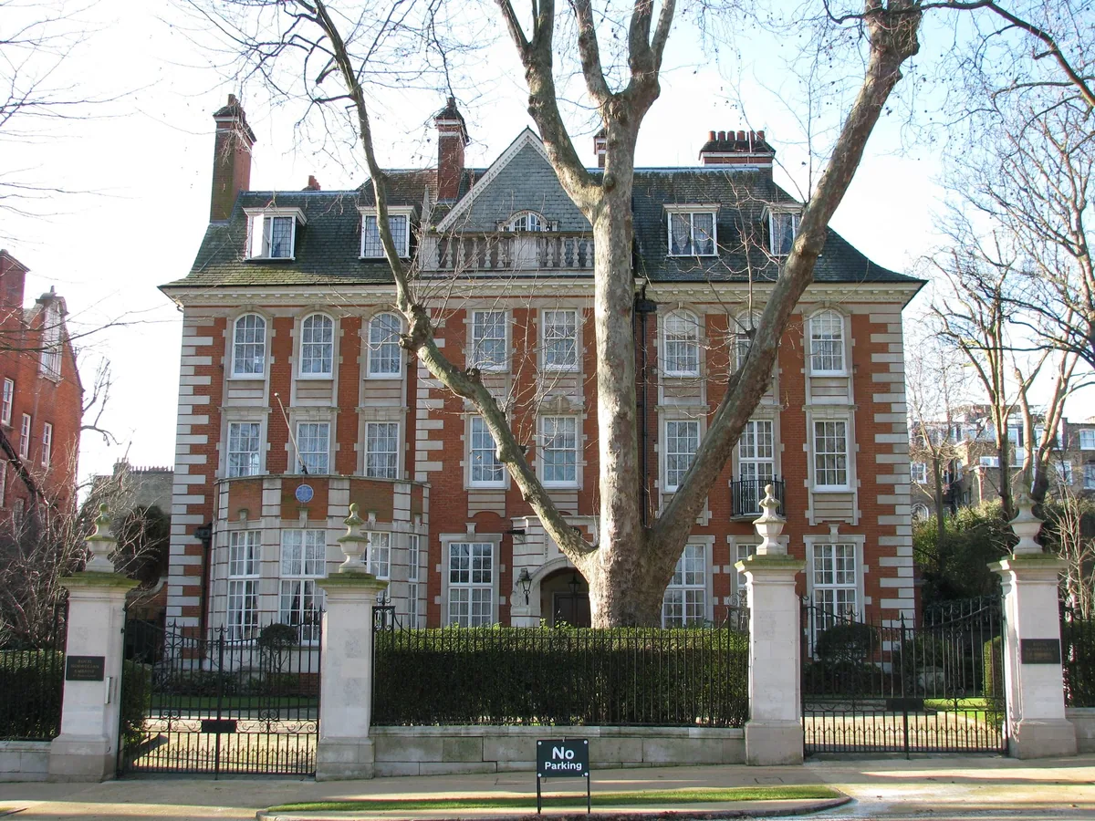 Rød murvilla på Palace Green i Kensington med blått minneskilt på fasaden, bak smijernsgjerde og et stort platantre