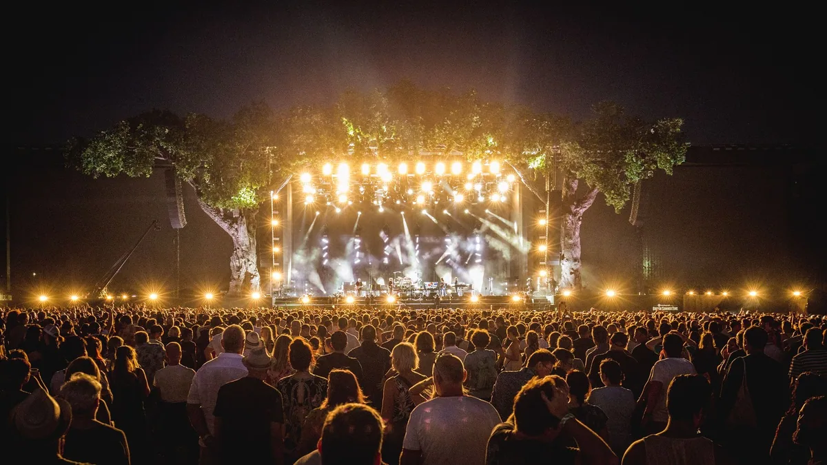 Konsert på BST Hyde Park om kvelden, med scenen mellom to kunstige eiketrær og et stort publikum foran