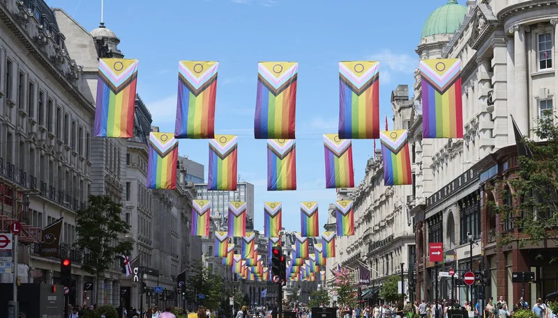 Rekker med Progress Pride-flagg hengt over Regent Street en solrik sommerdag