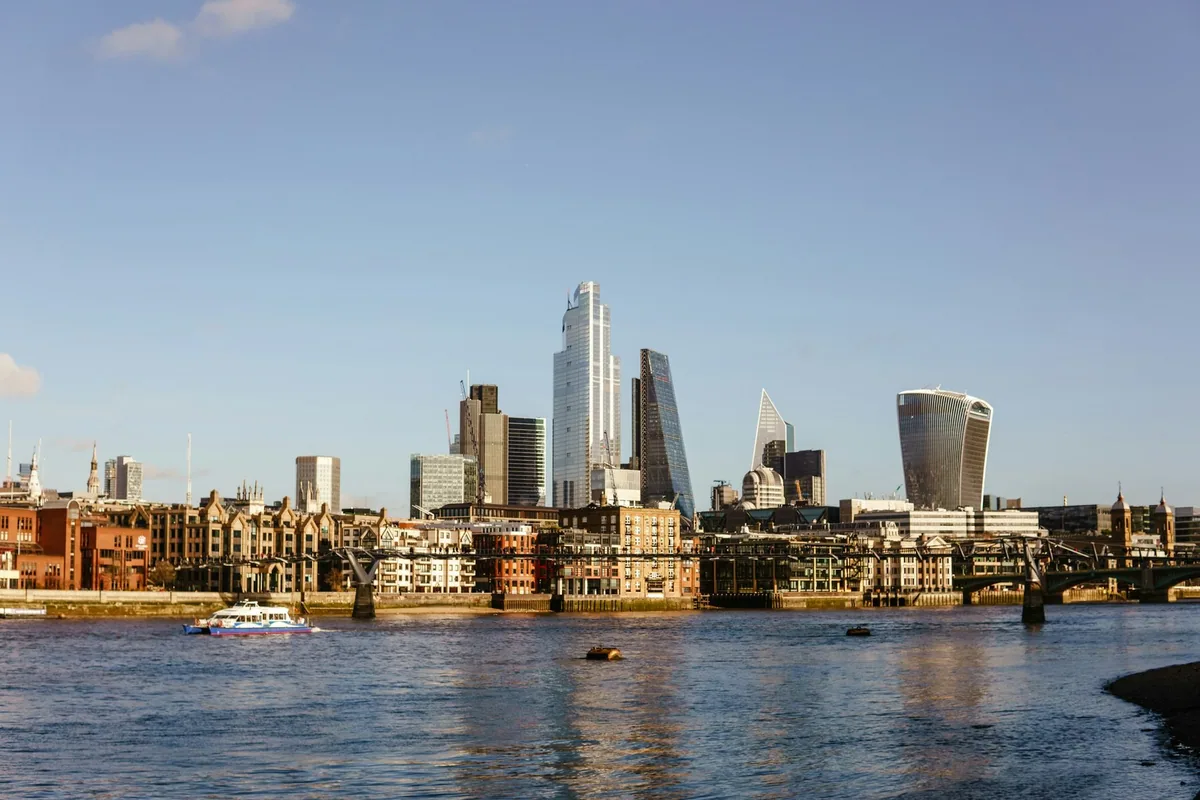 Skyskraperne i City of London, blant dem Walkie-Talkie, over rader av eldre bygninger en solfylt dag