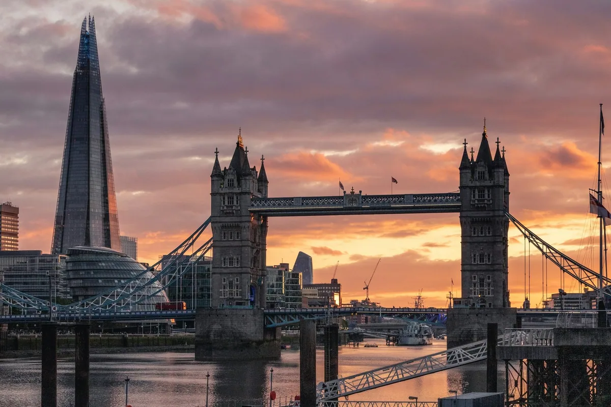 Tower Bridge og The Shard mot en rosa og oransje solnedgangshimmel over Themsen