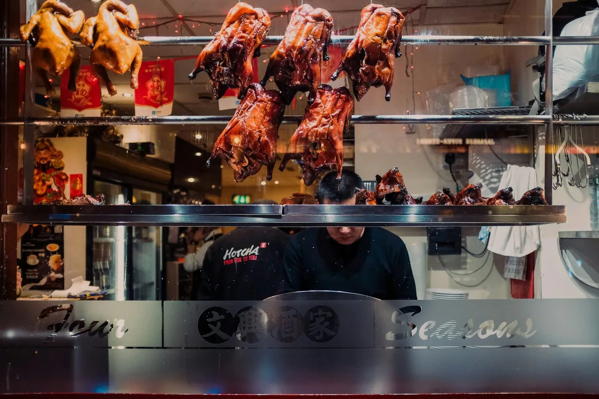 Glinsende stekte ender henger i vinduet til en kinesisk restaurant i Chinatown