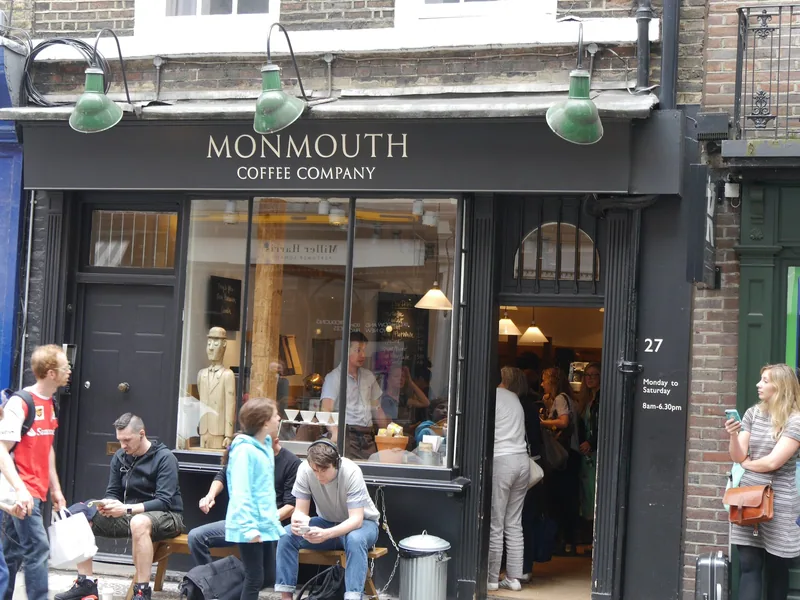 Fasaden til Monmouth Coffee Company i Monmouth Street i Covent Garden, med gjester på benken utenfor