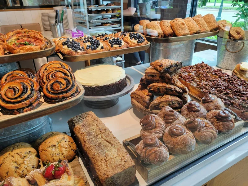 Kanelsnurrer, blåbærbakst, kake og sjokoladebakst ved siden av hverandre i en bakeridisk