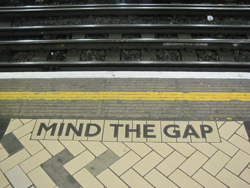 «Mind the gap» skrevet i flisene på perrongkanten ved Victoria stasjon på Londons undergrunn