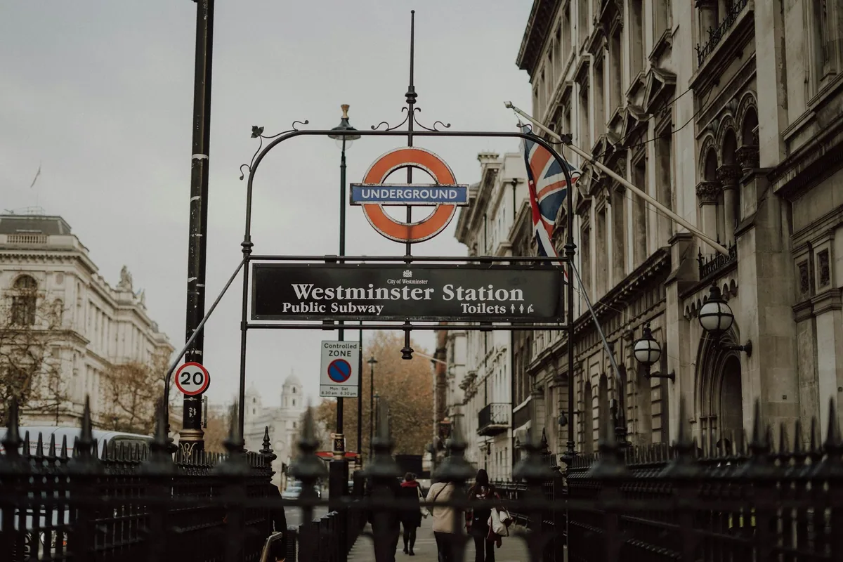 Skiltbue med Underground-logo og skilt til Westminster Station, offentlig undergang og toaletter