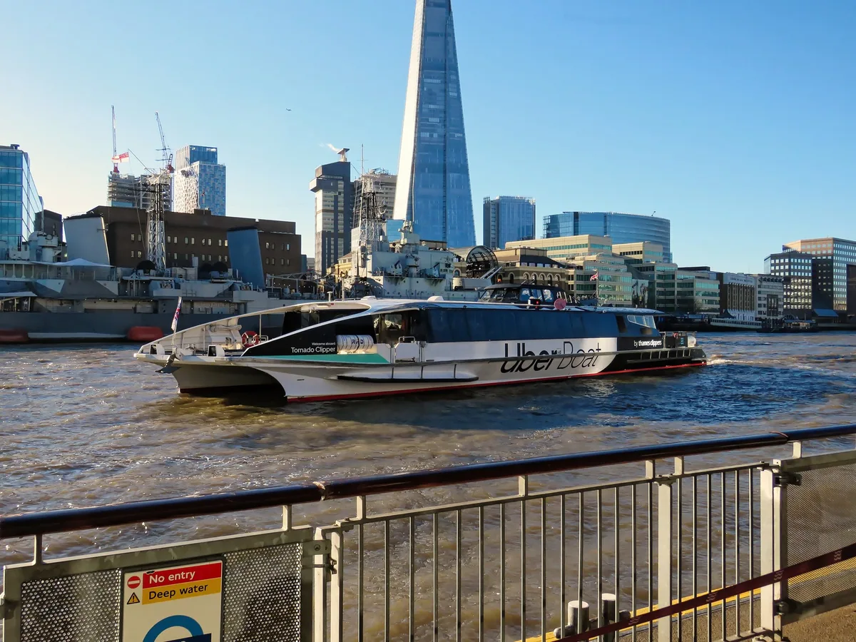 Elvebåten Tornado Clipper på Themsen foran HMS Belfast og The Shard, sett fra Tower Millennium Pier