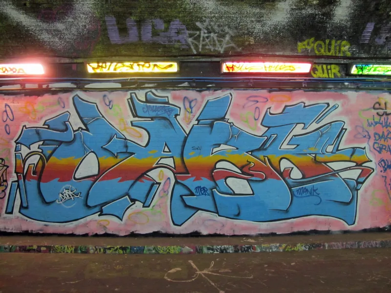 Fargerik graffiti i blått, rødt og gult på en vegg i Leake Street-tunnelen ved Waterloo