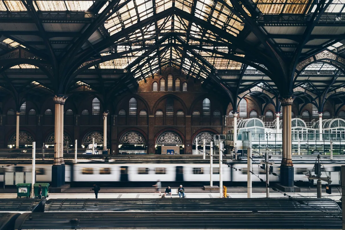 Tog passerer under det buede glasstaket på Liverpool Street stasjon
