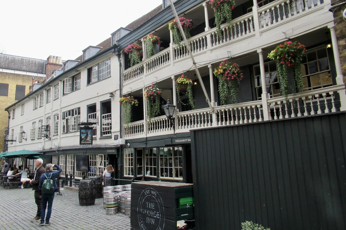 Den gamle vertshuspuben The George Inn i Southwark med hvite svalganger og blomsterkasser