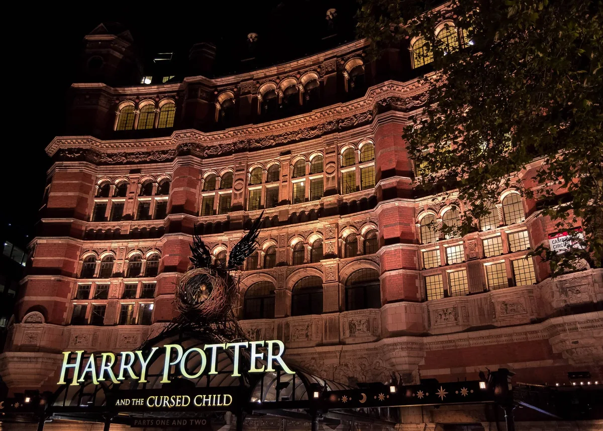 Den opplyste teglfasaden til Palace Theatre ved Cambridge Circus i West End en kveld, med rader av buede vinduer