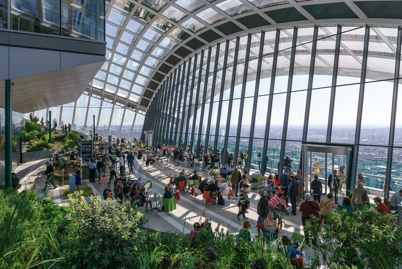 Sky Garden på toppen av Walkie-Talkie-bygget, med beplantning, kafébord og store glassvegger mot byen