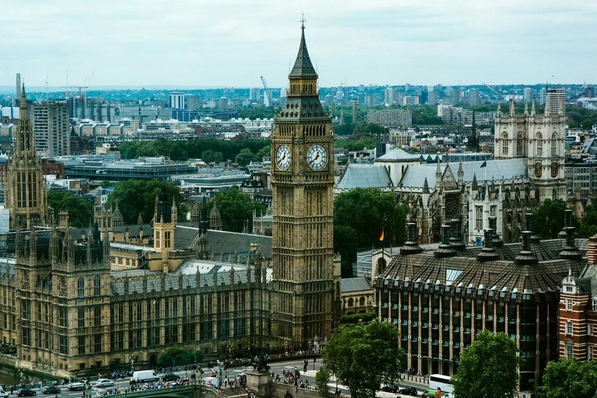 Big Ben og Parlamentet sett ovenfra, med Westminster Abbey og byen bak