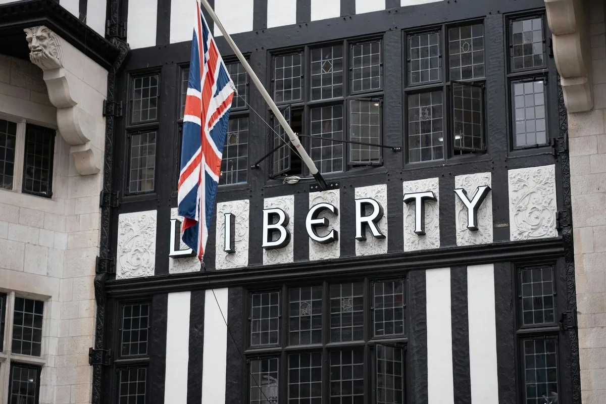 Den svarte og hvite bindingsverksfasaden til Liberty med navnet i store bokstaver og et britisk flagg