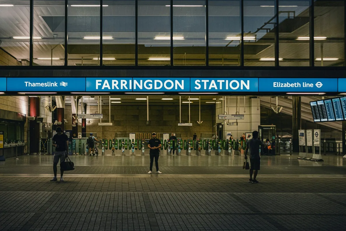 Inngangen til Farringdon stasjon med skilt for både Thameslink og Elizabeth line over billettsperrene