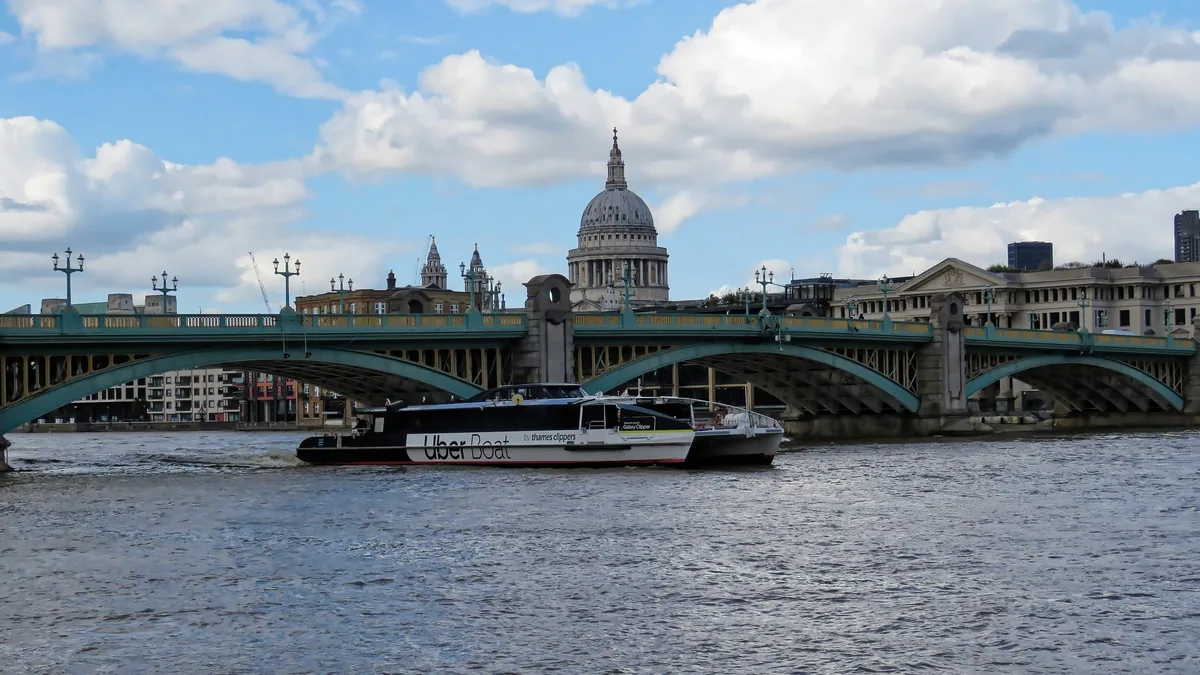 Uber Boat-katamaran på Themsen ved Southwark Bridge, med kuppelen på St Paul's Cathedral bak