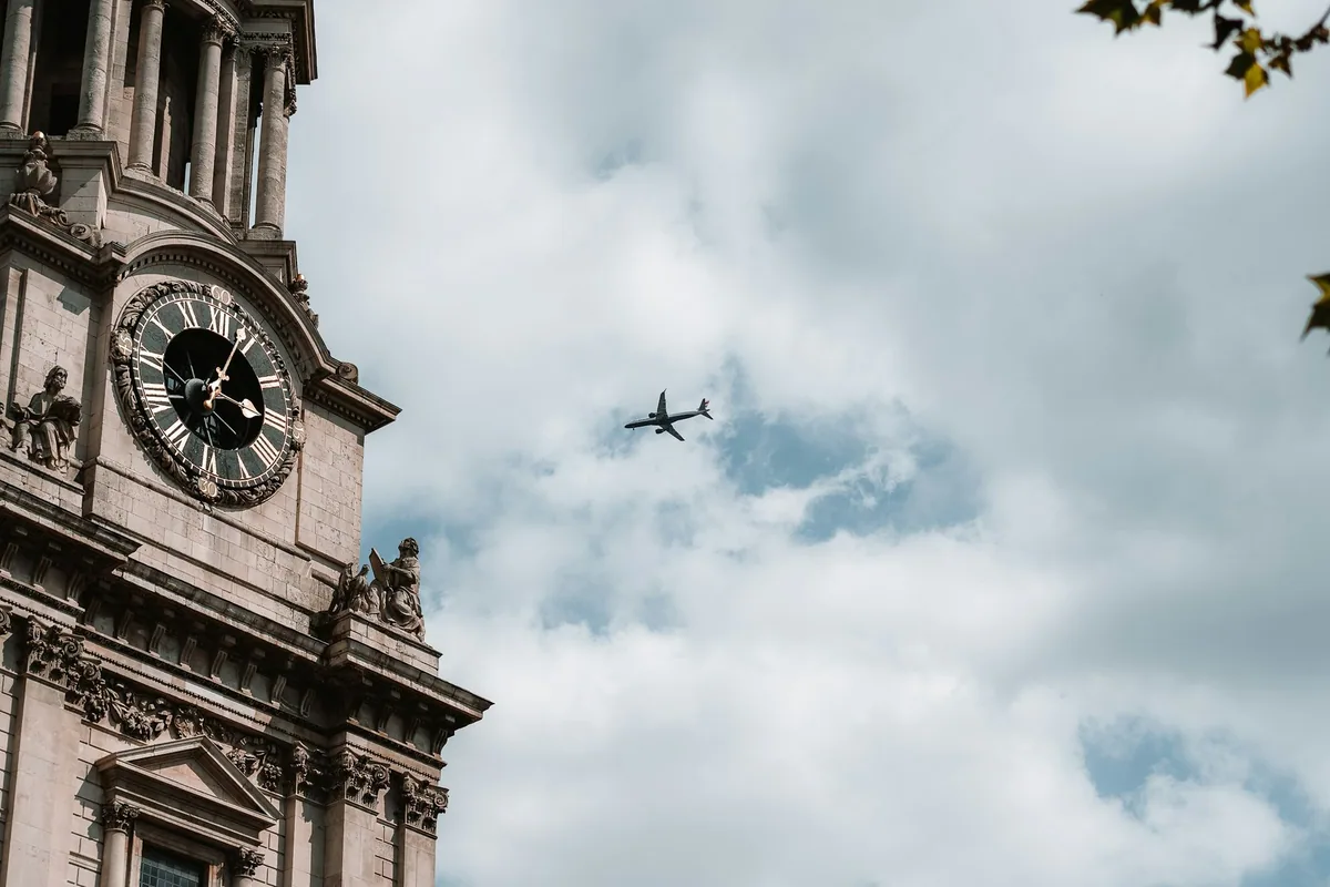 Et passasjerfly på vei over London, sett ved klokketårnet på St Paul's Cathedral