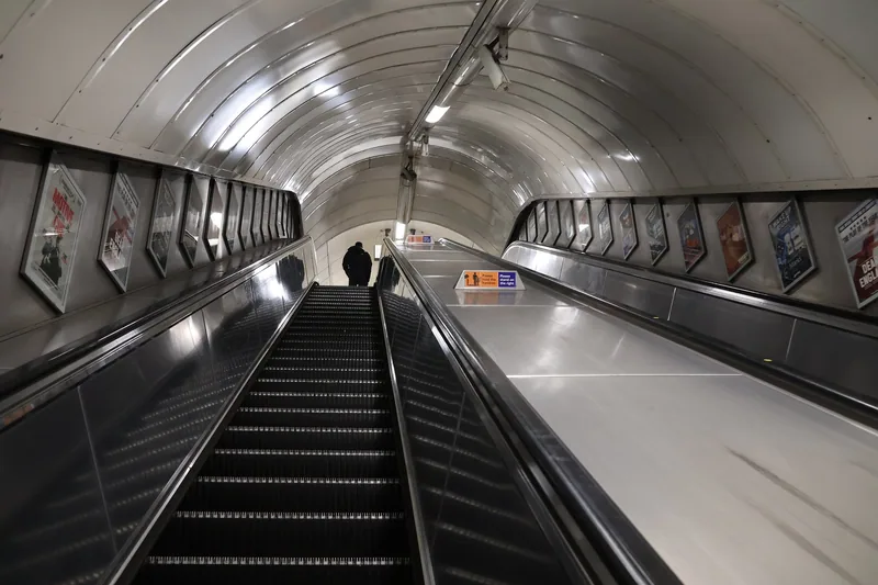Lange, nesten tomme rulletrapper i en rund tunnel på Oxford Circus stasjon