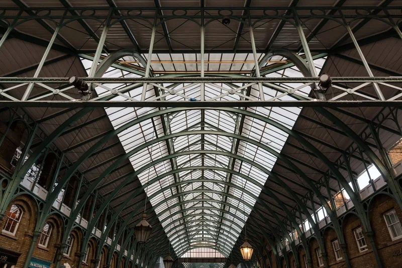 Glasstaket og de grønne jernbuene i markedshallen i Covent Garden, sett nedenfra